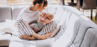 Rozstępy w ciąży, mama trzyma dziecko na rękach